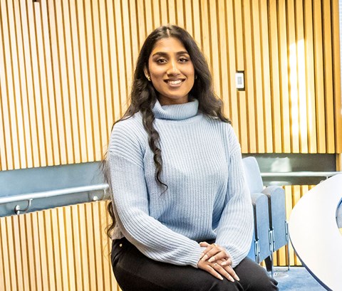 Students sitting in a lecture theatre and posing for a picture.
