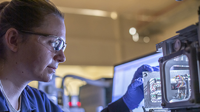 Scientist in protective goggles using lab equipment 