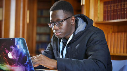 Student working in the law library on a laptop