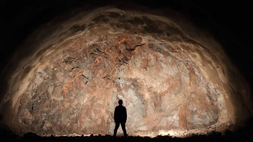 Mine, tunnel front, silhouette of a standing worker