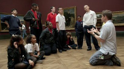 Man talking to children in art gallery