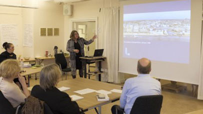 Woman giving presentation to small audience