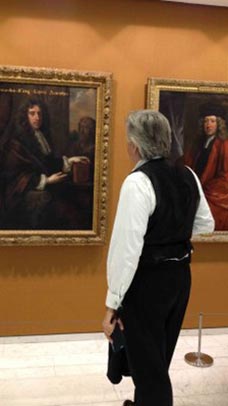 A man looking at paintings