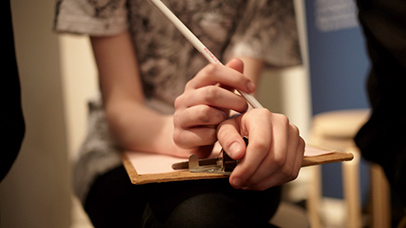 Woman's hands with pencil and clipboard