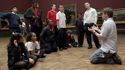 Man speaking to children in gallery