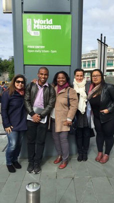 Scholars standing next to a sign for the World Museum