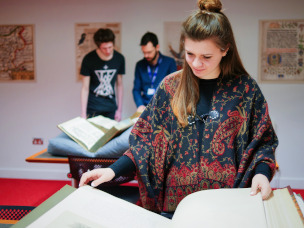 A female student reading from a book. 