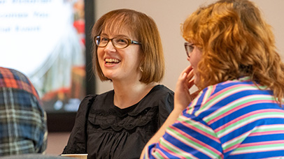 A women sitting in a group smiling