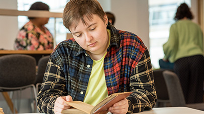 A person sitting and looking at a book