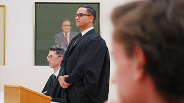 Law student in robes standing up