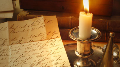 A handwritten letter and a candle on a table in a Victorian style.