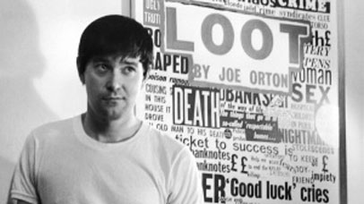 Joe Orton stood in front of a poster for Loot.