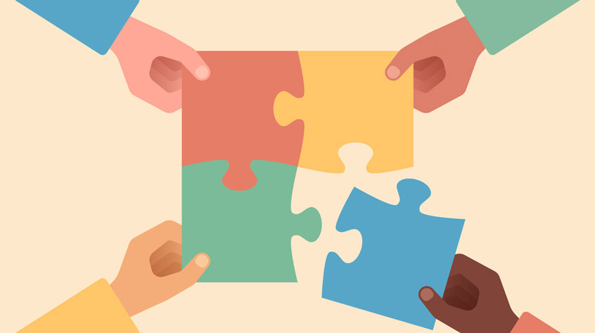 Hands putting a puzzle together teamwork concept.