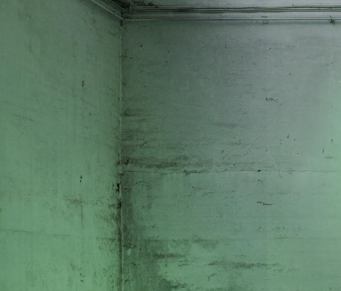 A laboratory scientist looks at a hovering illuminated globe comprised of glowing green lines, illustrating data being transferred around the world
