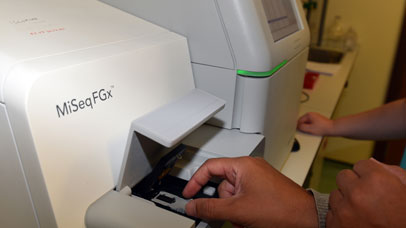 Someone using the MiSeqFGx machine in the Nucleus facility.