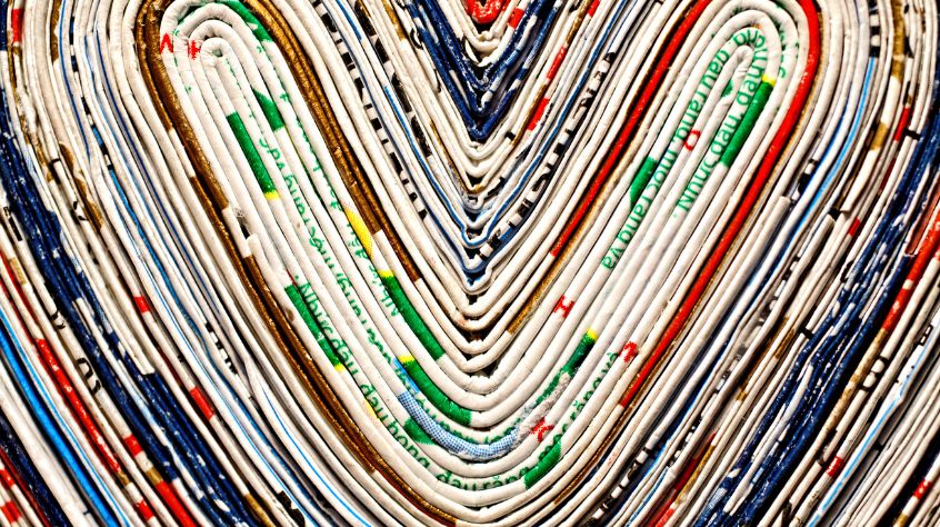 Colourful edges of newspaper forming the shape of a heart