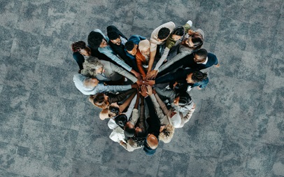 overhead shot large group of people with hands in central position