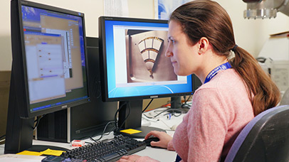 Women looking at a computer monitor and working with a keyboard and mouse at a desk