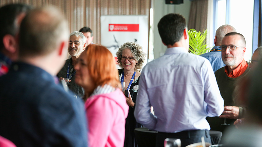 Members of staff mingling at an event at the University of Leicester
