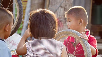 Children playing with a bicycle wheel