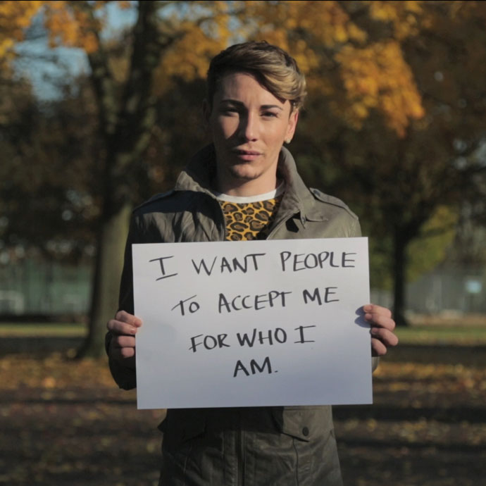Person holding a sign that reads: I want people to accept me for who I am