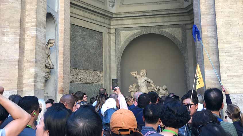 Crowds gathered around a statue.