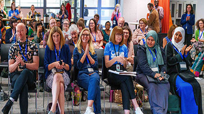 An audience smiling and clapping