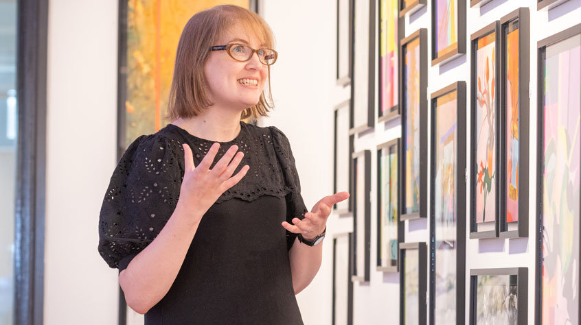 Person talking in front of a wall of art