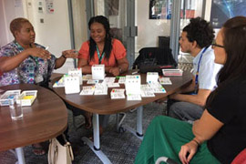 four people sat round a table in discussion