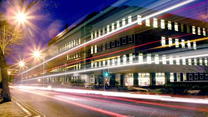 night time shot of the Maurice Shock Building, with abstract streetlights and road lights