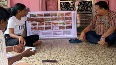 A workshop taking place with people observing a display board