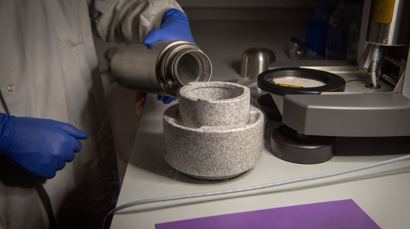 Scientist pouring liquid into another receptacle