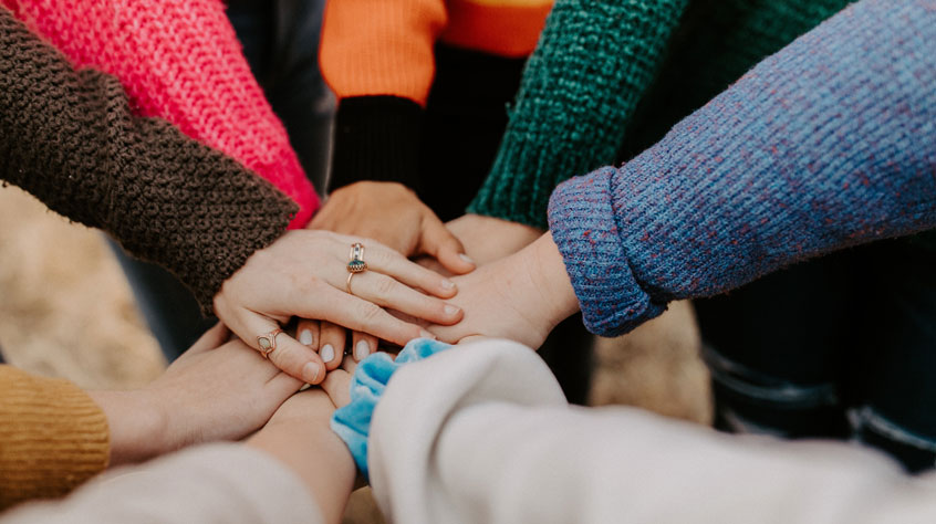 Picture of a group of hands one on top of each other to represent team work