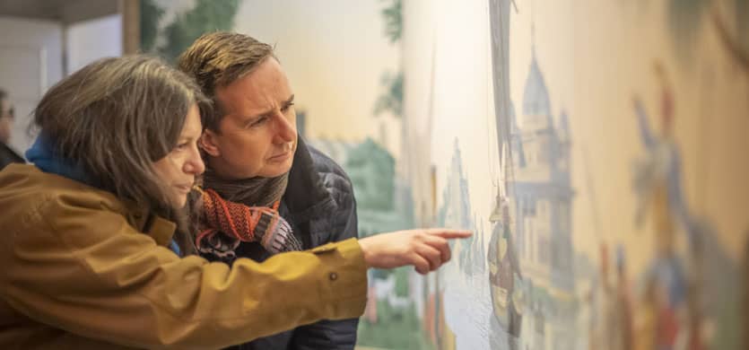 A man and woman examining art