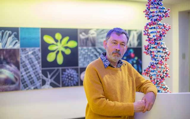 Mark Jobling standing near a 3D double helix model.