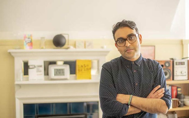 Neil Chakraborti in front of a fireplace.