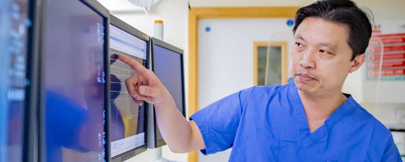 A doctor pointing at a computer screen