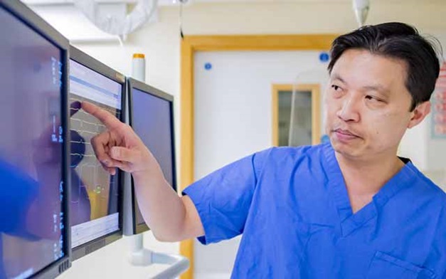 Andre Ng pointing at an x-ray