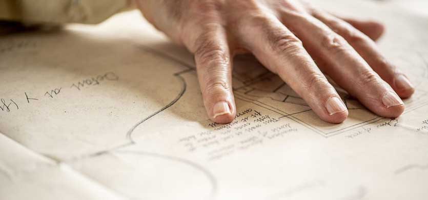 Close-up of a hand on a physical recording of an archaeological heritage site.