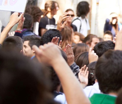 A crowd of protesters raise their hands in unity