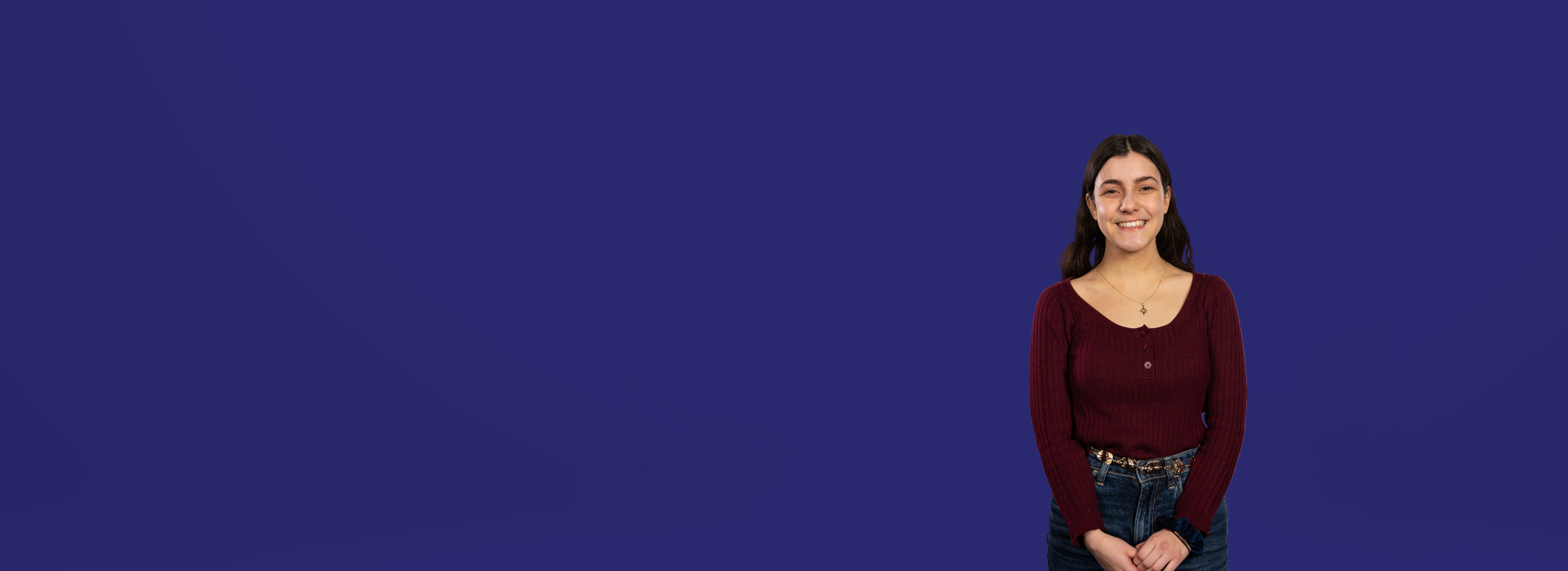 Student Charlotte looking into camera with a dark blue background behind her.