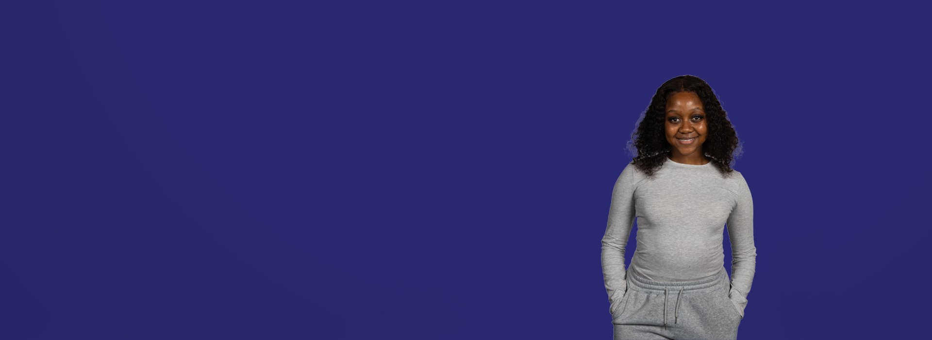 Student Natasha looking into camera with a dark blue background behind her.