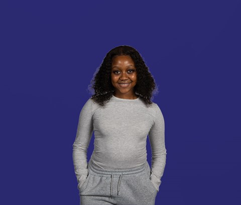 Student Natasha looking into camera with a dark blue background behind her.