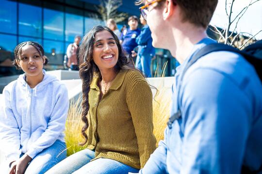 Smiling students outside in sunshine
