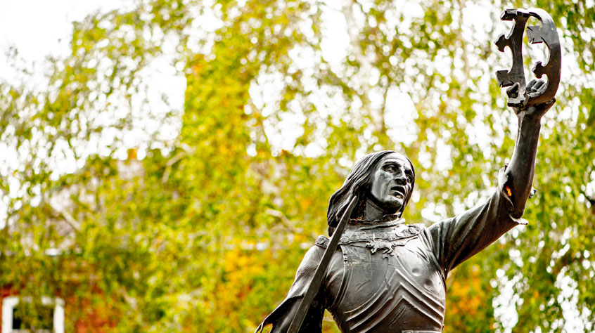 Richard III statue in Leicester with a backdrop of trees.