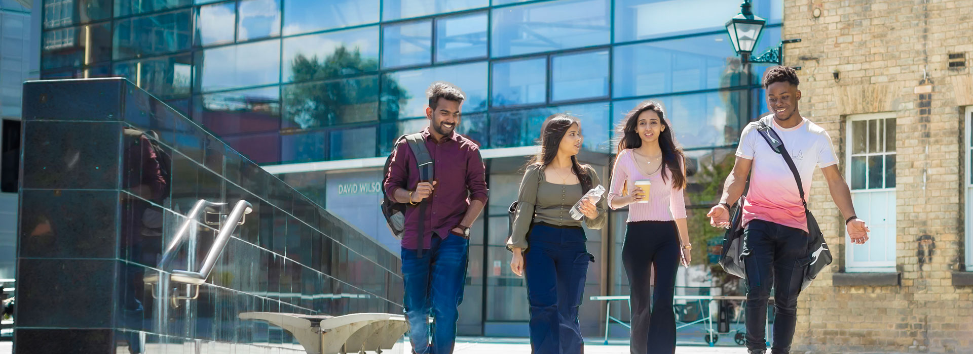 Students walking outside the library on Leicester campus.