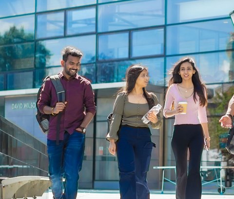 Students walking outside the library on Leicester campus.