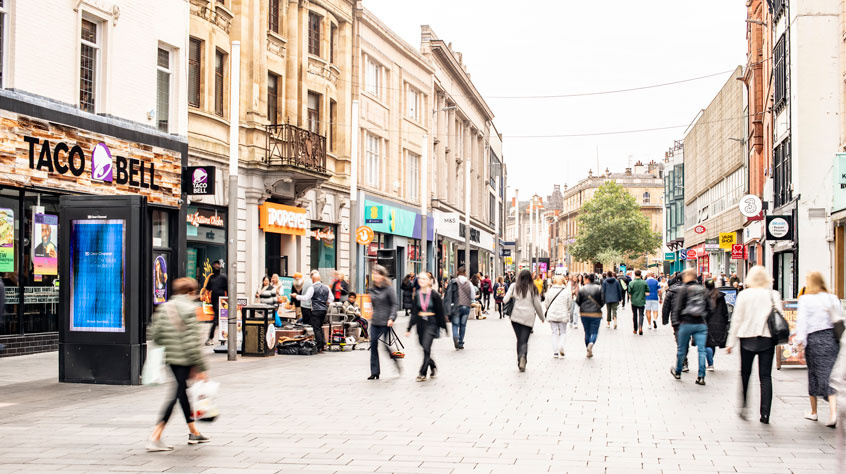 People walking along a busy city centre street