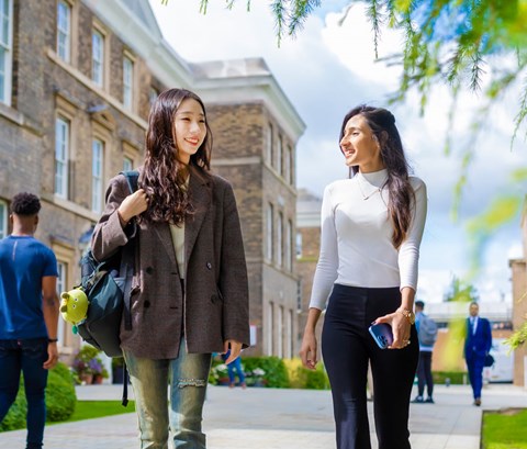 Students walking past the Fielding Johnson Building on a sunny day
