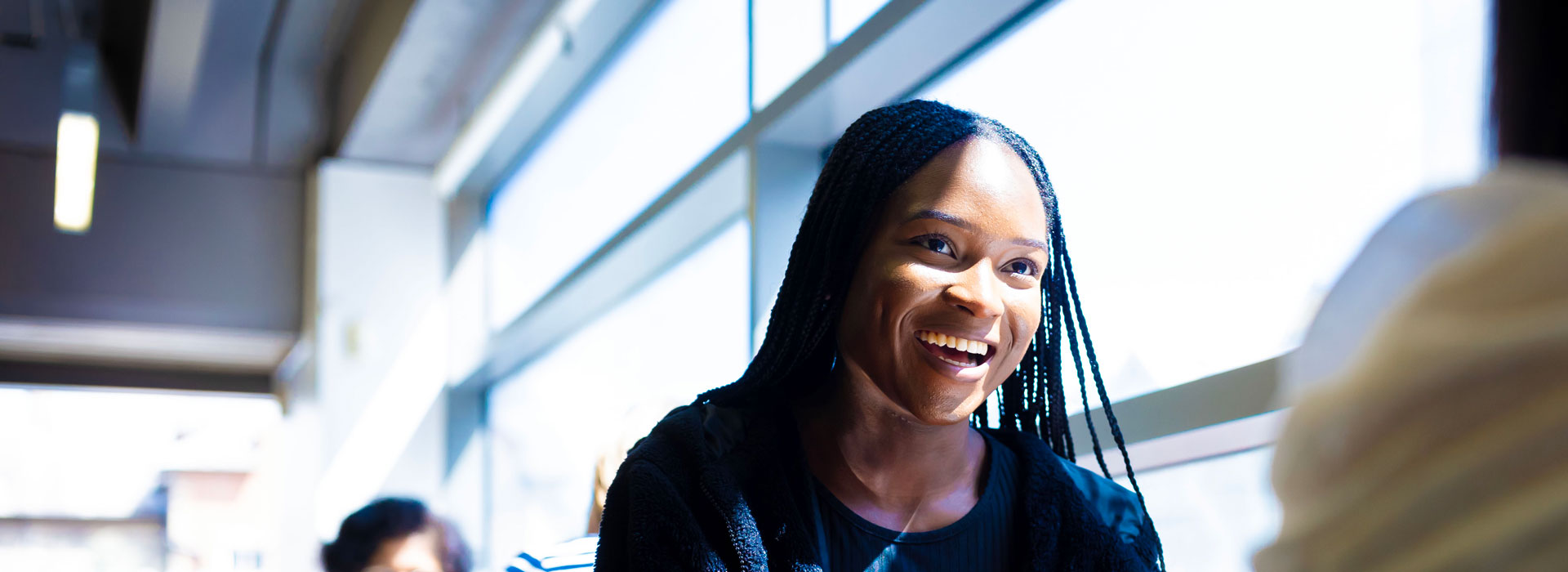 Student sitting in the library cafe with a friend and smiling